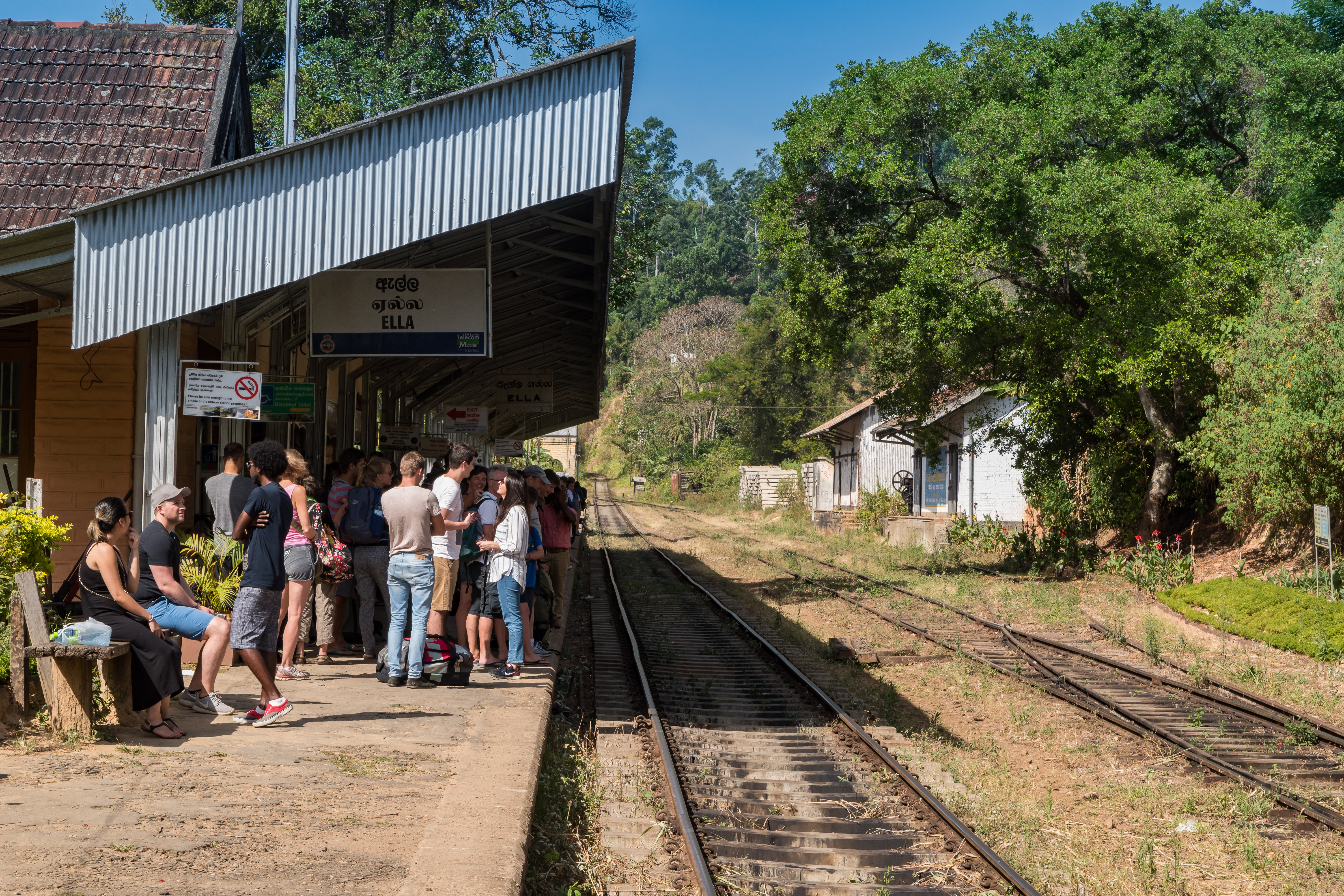 Railway station at Ella with train on the tracks, surrounded by green hills