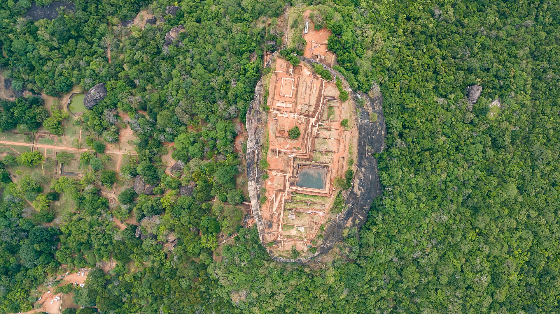 An aerial view of Sigiriya Rock rising from the dry-zone forest of Sri Lanka’s Cultural Triangle, with the surrounding plains and waterways below